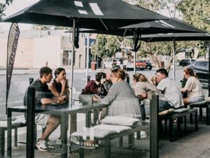 People eating at tables outdoors